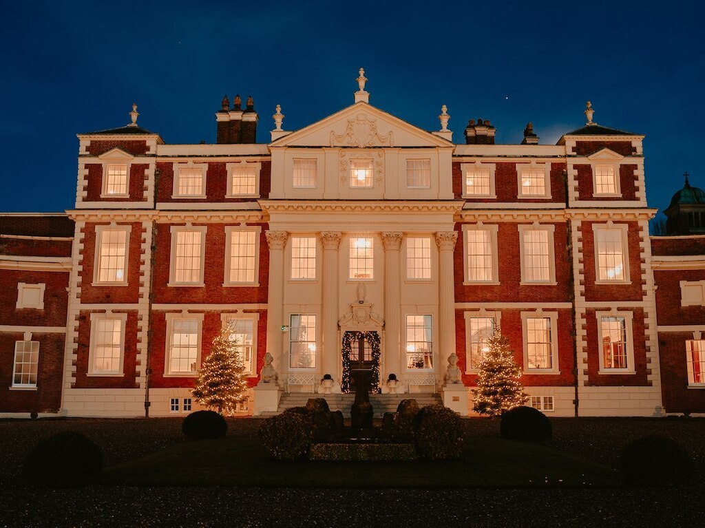 Hawkstone Hall & Gardens at night with decorated christmas trees either side of the steps and lit up